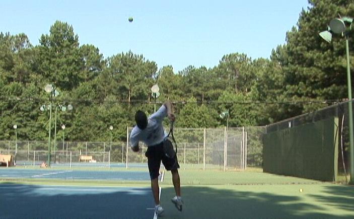 Tennis player Nick Lamart serving on court