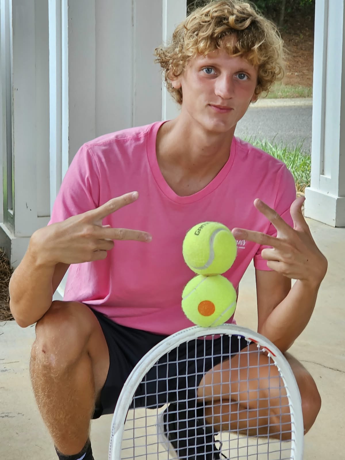 Teen tennis student balancing tennis balls on a racket
